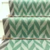 Green Herringbone stair runner with dark green woven border on white stairs
