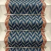 Blue Herringbone stair runner with orange woven border on white stairs