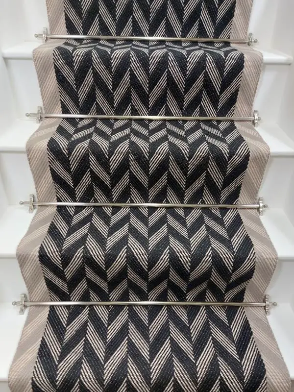 Black and white Herringbone Stair Runner with a grey woven border on white stairs