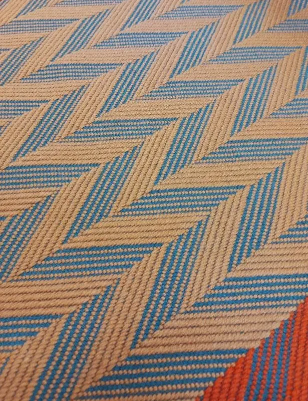 Cinnamon and Spruce Herringbone stair runner with vibrant red woven border on white stairs