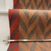 Cinnamon and Spruce Herringbone stair runner with vibrant red woven border on white stairs