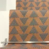 Cinnamon-coloured stair runner with green triangle pattern on white wooden stairs